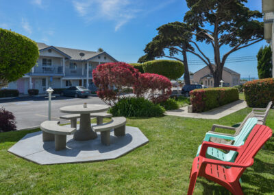 Charming outdoor garden seating area at Cayucos Beach Inn, offering a relaxing space to enjoy the coastal breeze and beautiful surroundings.